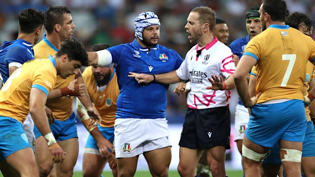 Referee Angus Gardner speaks with the players of Uruguay and Italy.