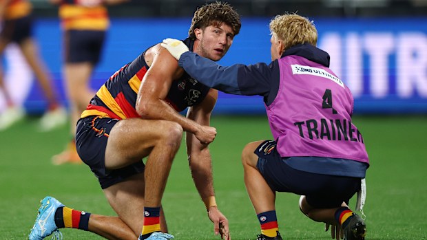Jordon Butts of the Crows receives medical attention.