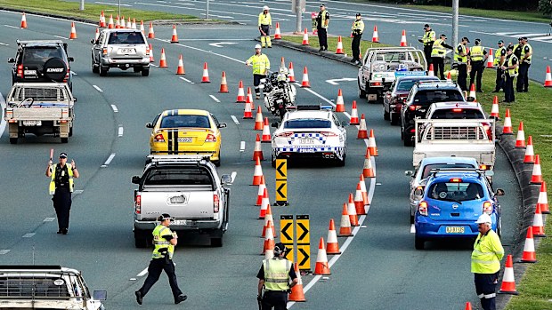 Motorists are stopped at a checkpoint on the Gold Coast Highway at Coolangatta on the Queensland/NSW border border , Thursday, March 26, 2020. 