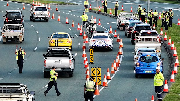 Motorists are stopped at a checkpoint on the Gold Coast Highway at Coolangatta on the Queensland/NSW border border , Thursday, March 26, 2020. 
