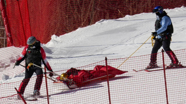 Paramedics carry down Dominik Schwaiger, of Germany, after he fell during the men's downhill.