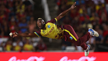 Andre Russell of the West Indies fields off his own delivery.