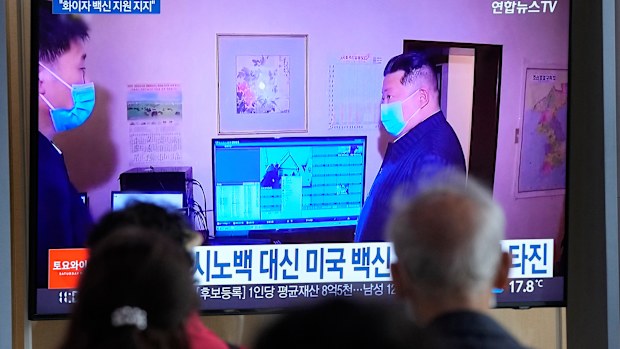 People watch a TV screen showing a file image of North Korean leader Kim Jong Un, right, during a news program at a train station in Seoul, South Korea,
