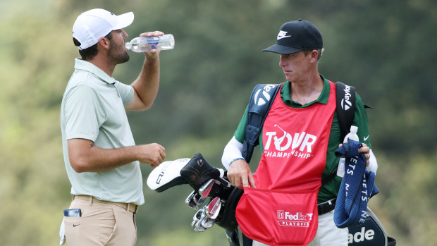 Scottie Scheffleris iš Jungtinių Amerikos Valstijų geria gėrimą antroje aikštelėje, o jo caddy Tedas Scottas žiūri į paskutinį TOUR čempionato etapą East Lake golfo klube 2024 m. rugsėjo 1 d. Atlantoje, Džordžijos valstijoje. (Nuotrauka Mike'o Mulhollando / Getty Images)