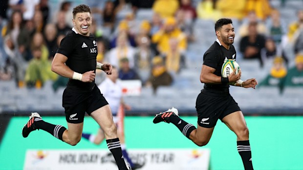 Beauden Barrett celebrates as Richie Mo'unga of the All Blacks runs in to score.