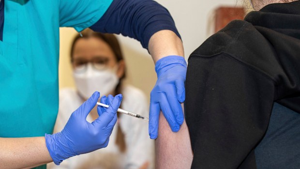 A doctor vaccinates a young woman with Moderna's mRNA vaccine at the Dresden State Art Collections in Dresden, Germany, Dec. 18, 2021. 