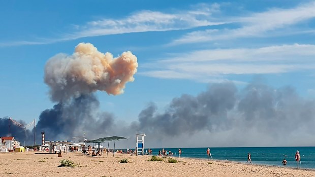 Rising smoke can be seen from the beach at Saky after explosions were heard from the direction of a Russian military airbase near Novofedorivka, Crimea, Tuesday Aug. 9, 2022. The explosion of munitions caused a fire at a military air base in Russian-annexed Crimea Tuesday but no casualties or damage to stationed warplanes, Russia's Defense Ministry said. (UGC via AP)