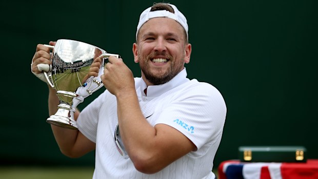 Dylan Alcott lifts the Wimbledon trophy.