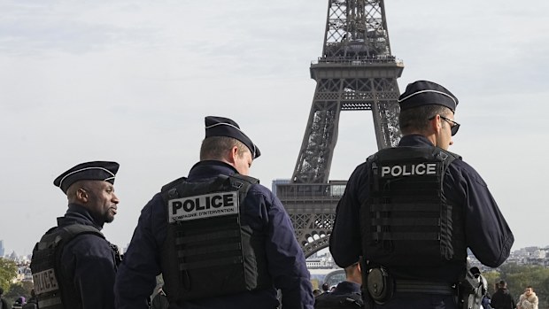 Police officers patrol the Trocadero plaza near the Eiffel Tower in Paris, Tuesday, Oct. 17, 2023.