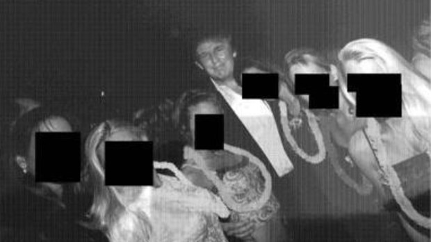 This undated, redacted photo released by Democrats on the House Oversight Committee shows Donald Trump standing with a group of women.