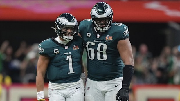 Philadelphia Eagles quarterback Jalen Hurts (1) is hugged by offensive tackle Jordan Mailata (68) after throwing a touchdown pass to wide receiver DeVonta Smith (6) during the second half of the NFL Super Bowl 59 football game, Sunday, Feb. 9, 2025, in New Orleans. (AP Photo/Matt Slocum)