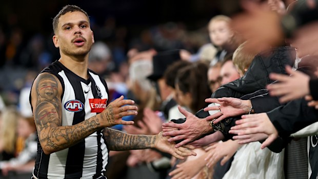 Bobby Hill of the Magpies high-fives fans.