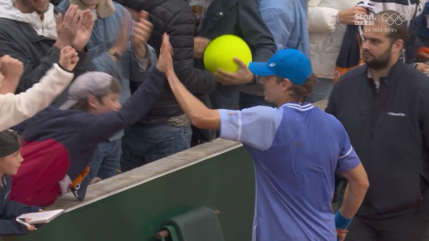 Alex De Minaur give a young fan a high five after securing a spot in the fourth round at Roland-Garros with a win over Jan-Lennard Struff.