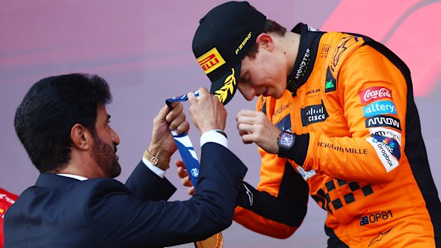 Race winner Oscar Piastri of Australia and McLaren is presented with his medal by Mohammed ben Sulayem, FIA President, on the podium during the F1 Grand Prix of Azerbaijan.