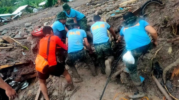 Rescuers retrieve bodies during the search and rescue operations due to landslides caused by Tropical Storm Nalgae in Barangay Kushong, Datu Odin Sinsuat, Maguindanao province, southern Philippines on Friday Oct. 28, 2022.