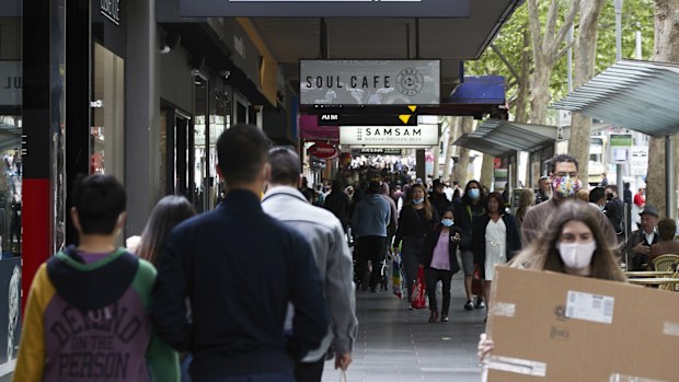 Shoppers walk past stores on Swanston Street in Melbourne. 