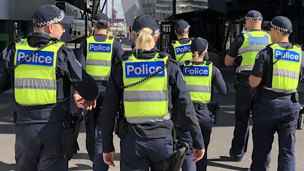 A group of uniformed members of Victoria Police on patrol.