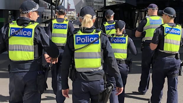 A group of uniformed members of Victoria Police on patrol.