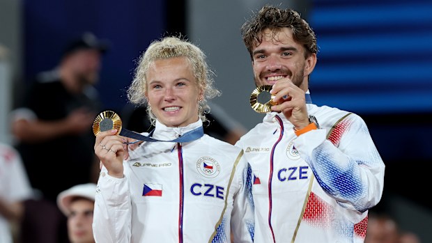 Katerina Siniakova and Tomas Machac celebrate on the podium.