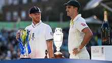 Pat Cummins of Australia and Ben Stokes of England pose with the Ashes trophy.