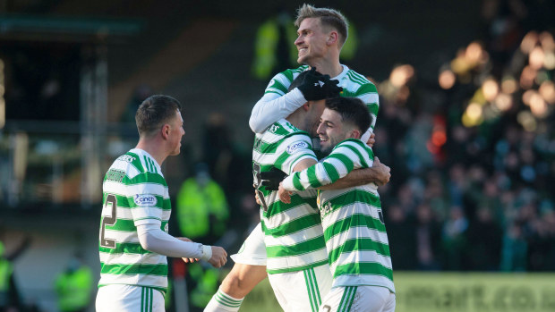 Tom Rogic is mobbed by his Celtic teammates after scoring a stunner.