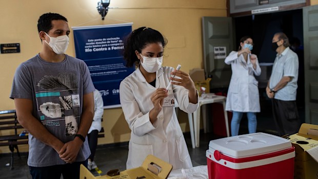 A health worker prepares a shot of the AstraZeneca vaccine for COVID-19 during a vaccination campaign for people over age 35 in Rio de Janeiro