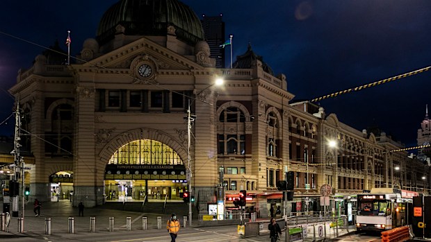 People crossing Flinders Street amid lockdown in Melbourne, Australia. 