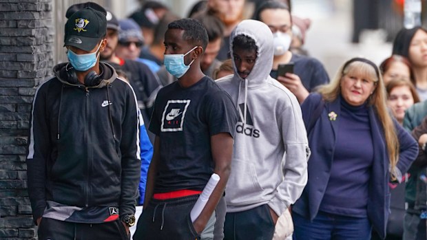 People are seen in long queue outside a Centrelink office in Abbotsford, Melbourne, Monday, 