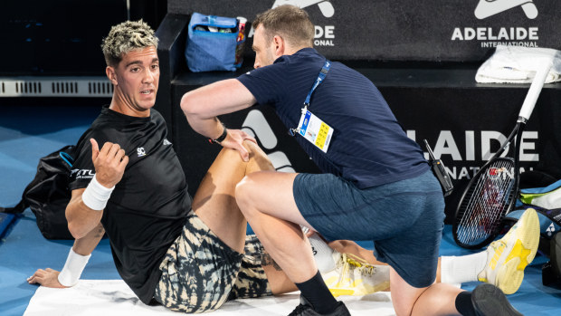 ADELAIDE, AUSTRALIA - JANUARY 02: Thanasi Kokkinakis of Australia seeks treatment for his knee during his match against Maxime Cressy of the USA during day two of the 2023 Adelaide International at Memorial Drive on January 02, 2023 in Adelaide, Australia. (Photo by Sue McKay/Getty Images)