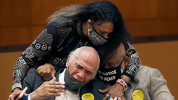 Rose Grayson, niece of Francis DeSales Grayson, top, comforts James Grayson, son of Francis DeSales Grayson, left, and Rudy MCollum, great nephew of Francis DeSales Grayson, one of the Martinsville Seven after posthumous pardons issued.