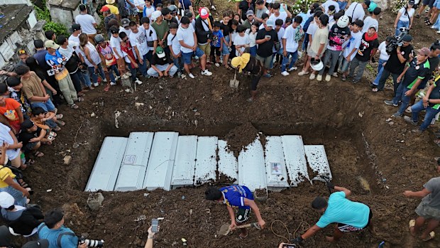 Families gather during the burial of earthquake victims at the New Corazon Cemetery in Bogo City, Cebu province, central Philippines on Wednesday, Oct. 8, 2025. 