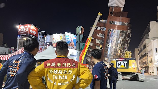 Rescue workers stand near the site of a leaning building in the aftermath of an earthquake in Hualien, eastern Taiwan on Wednesday, April 3, 2024