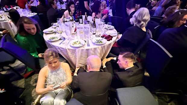 Guests take cover behind a table after US President Donald Trump and first lady Melania Trump were rushed out of the White House Correspondents' Association dinner by Secret Service agents.