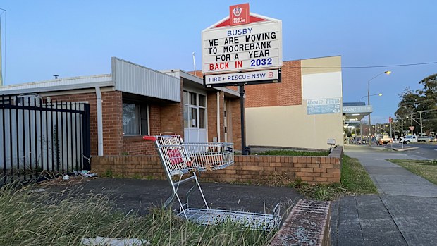 A shopping trolley and a sign that reads 'we are moving to Moorebank, back in 2023' sits in front of the old fire station.