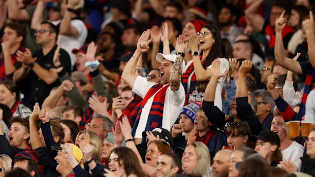 Demons fans celebrate during the round one grand final rematch between Melbourne and the Western Bulldogs.
