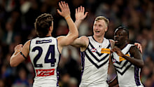 Josh Treacy celebrates with his Dockers teammates after kicking a goal.