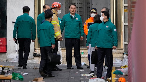 South Korean President Yoon Suk Yeol, center, visits the scene where dozens of people died and were injured in Seoul, South Korea.