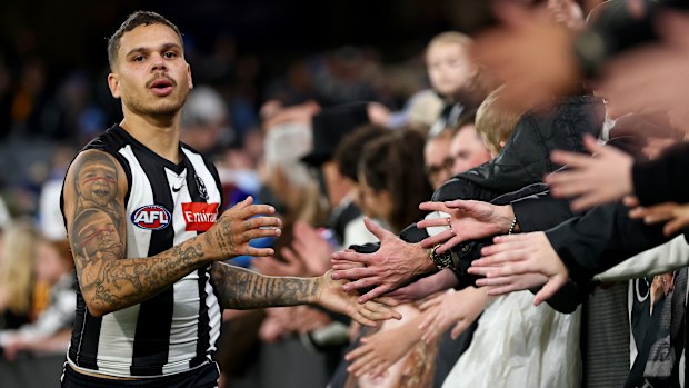 Bobby Hill of the Magpies high-fives fans.