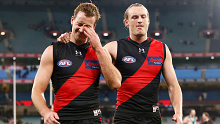 Darcy Parish (left) and Mason Redman of the Bombers look dejected as they leave the field after their round 16 loss to Port Adelaide.