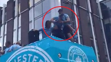 Teammates catch Jack Grealish before he falls off the Manchester City bus.