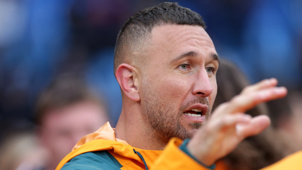 Quade Cooper talks to a teammate from the sidelines after his injury.