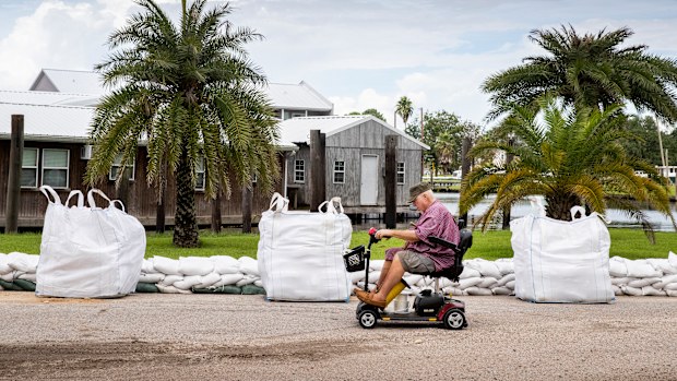 Keith Clark brings a friend rope to help tie down a houseboat before he evacuates to Mandeville ahead of Hurricane Ida in Jean Lafitte, Louisiana. (Photo by Sophia Germer, NOLA.com, The Times-Picayune | The New Orleans Advocate)
