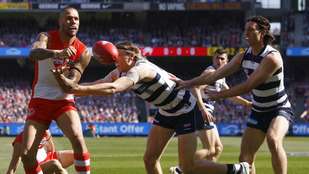 Lance Franklin of the Swans  handballs under pressure from Mark Blicavs of the Cats during the 2022 AFL Grand Final match between the Geelong Cats and the Sydney Swans at the Melbourne Cricket Ground on September 24, 2022 in Melbourne, Australia. (Photo by Daniel Pockett/AFL Photos/via Getty Images)