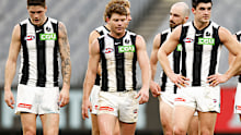 Magpies players leave the field looking dejected.