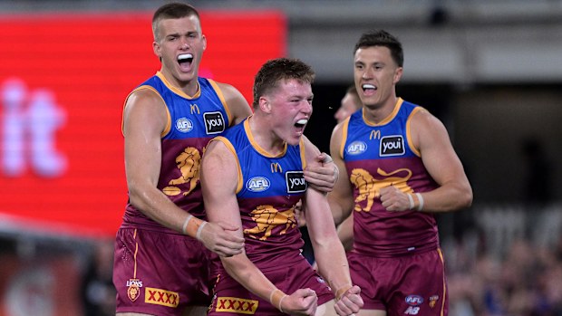 Logan Morris of the Lions celebrates after kicking a goal.