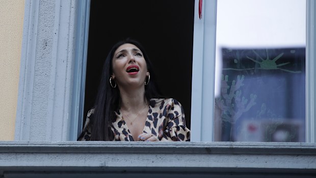 Opera singer Laura Baldassari leans out of her window to sing as the country tired to boost morale.