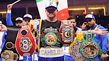 Canelo Alvarez poses with his belts after beating William Scull.