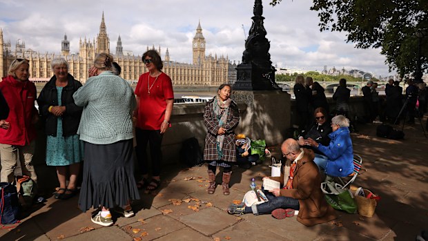 Well-wishers reading books, sitting on fold out chairs and chatting by the river Thames across from the houses of Parliament ahead of the procession for the Lying-in State of Queen Elizabeth II on September 14, 2022 in London, England. Queen Elizabeth II's coffin is taken in procession on a Gun Carriage of The King's Troop Royal Horse Artillery from Buckingham Palace to Westminster Hall where she will lay in state until the early morning of her funeral. Queen Eliz