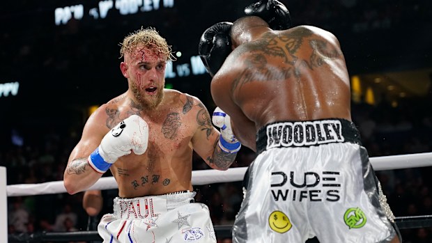 Jake Paul, left, punches Tyron Woodley during the second round of their rematch fight.