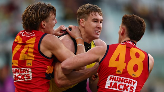 Tom Lynch of the Tigers wrestles with Josh Worrell and Mark Keane of the Crows.